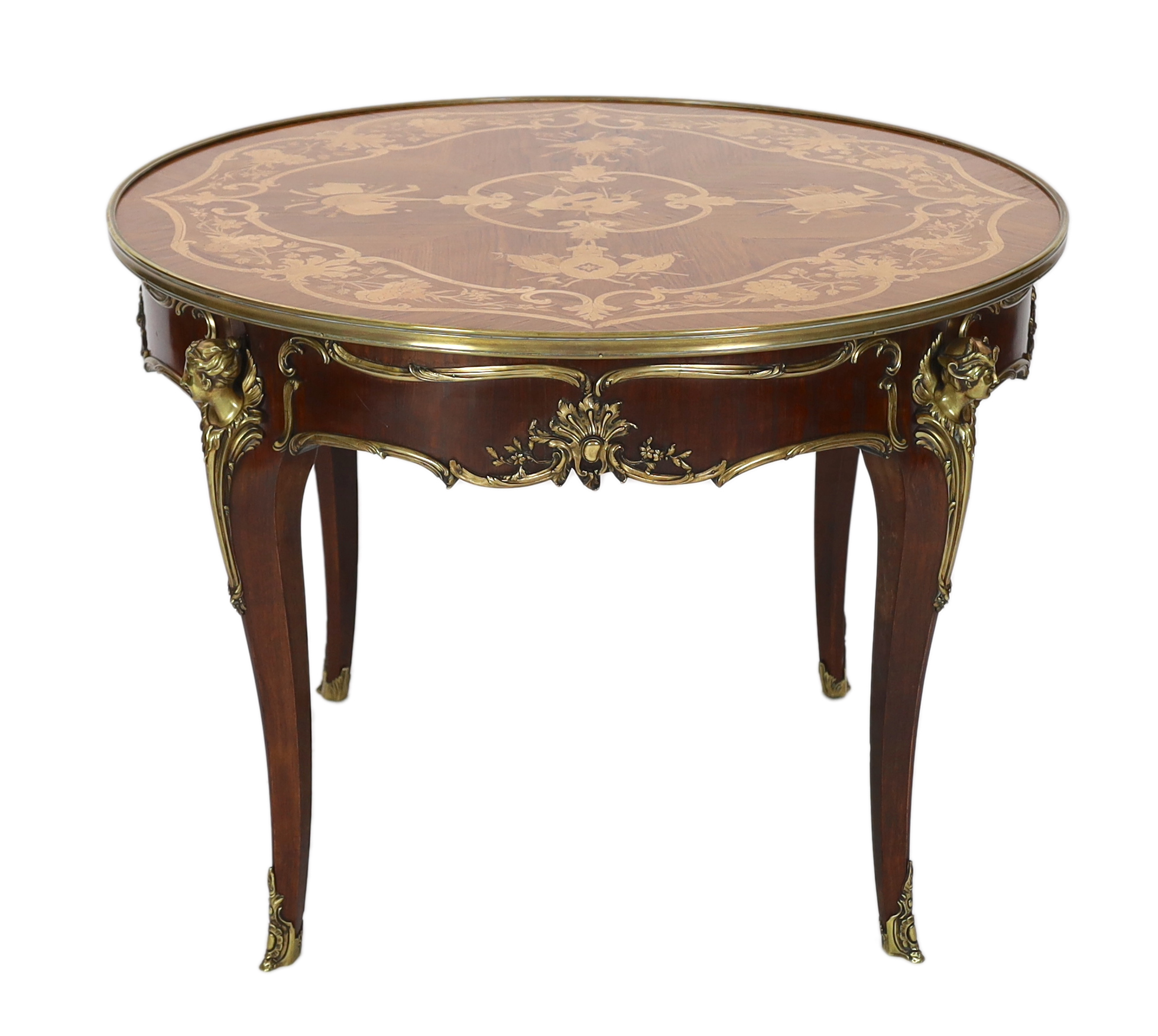 A Louis XVI style ormolu mounted marquetry centre table, decorated with musical, agricultural and arts related trophies within a band of flowers, the circular top over a scroll mounted frieze with classical mask headed c
